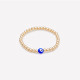 Yellow gold beaded bracelet with blue glass evil eye as seen in vanity fair for kids