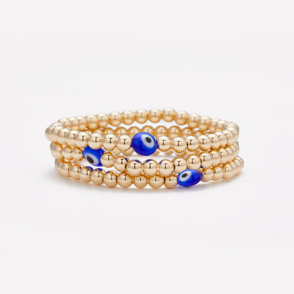 Yellow gold beaded bracelet with blue glass evil eye stack as seen in vanity fair for kids